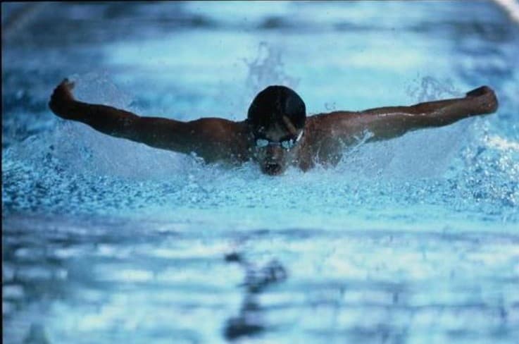 Swimmer demonstrating a powerful butterfly stroke during swim coaching